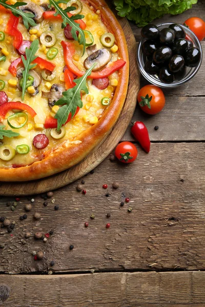 Delicious pizza with vegetables on wooden background — Stock Photo, Image