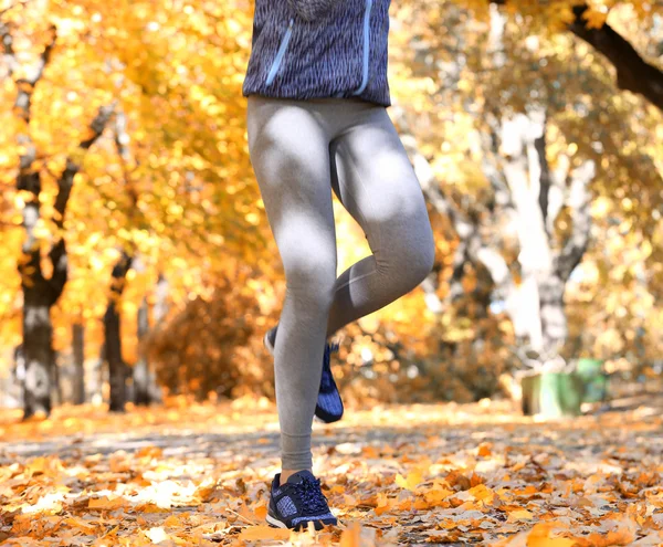 Kvinnan jogging i höst park — Stockfoto