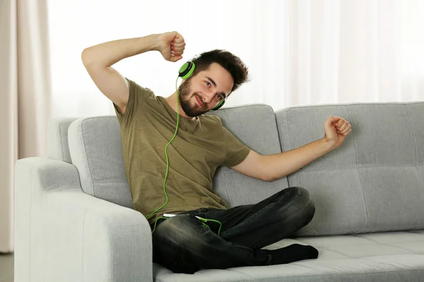 Junger Mann hört Musik mit Kopfhörern — Stockfoto