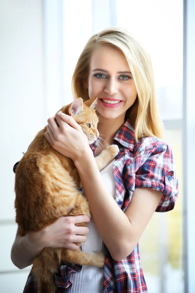 Mujer joven posando con gato rojo — Foto de Stock