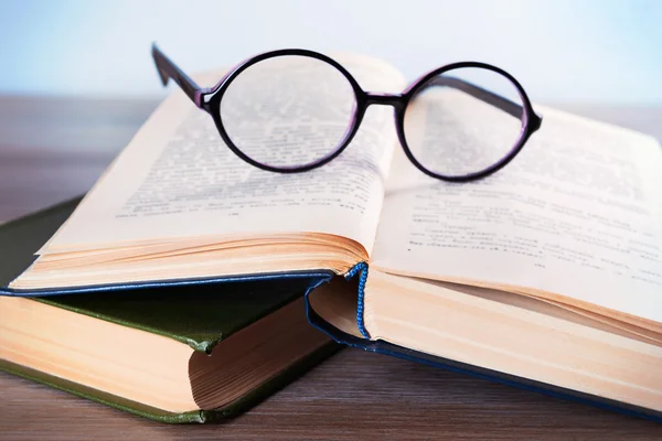 Livres et lunettes sur table en bois — Photo