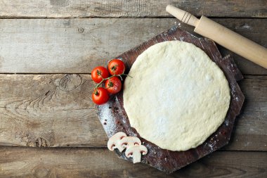 Taze hamur pizza domates ve ahşap bir gemide dilimlenmiş mantar ile hazırlanan yakın çekim