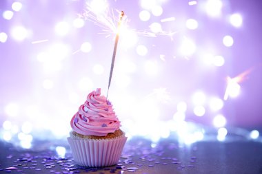 Cupcake pembe krema buzlanma ve pırıltılı glitter arka plan üzerinde