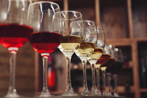 Molti bicchieri di vino diverso in fila sul bancone del bar — Foto Stock