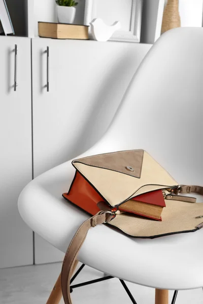 Handbag with book on white chair — Stock Photo, Image