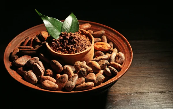 Kom met aromatische cacao oogst op houten achtergrond, close-up — Stockfoto