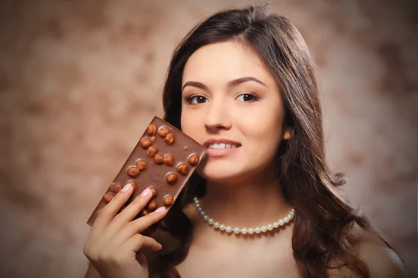 Portret van mooie jonge vrouw met chocolade, close-up — Stockfoto