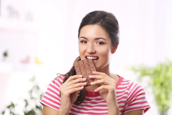 Portrait of beautiful young brunette with chocolate in the room , close up — Stock Photo, Image