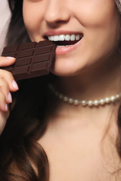 Amar chocolate mulher morde bar para desfrutar do sabor, close-up — Fotografia de Stock