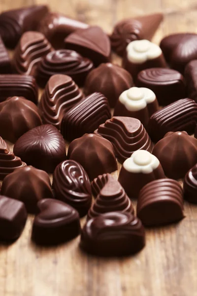 Delicious chocolate candies on wooden background — Stock Photo, Image