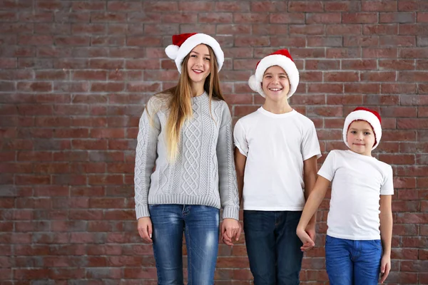 Meninos e menina em chapéus de Santa — Fotografia de Stock