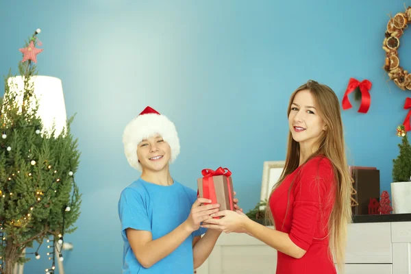 Ragazza Presenta Regalo Ragazzo Nella Stanza Decorata Natale — Foto Stock