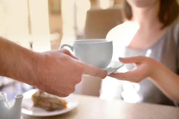 Waiter serving tea to customer in cafe — Stock Photo, Image