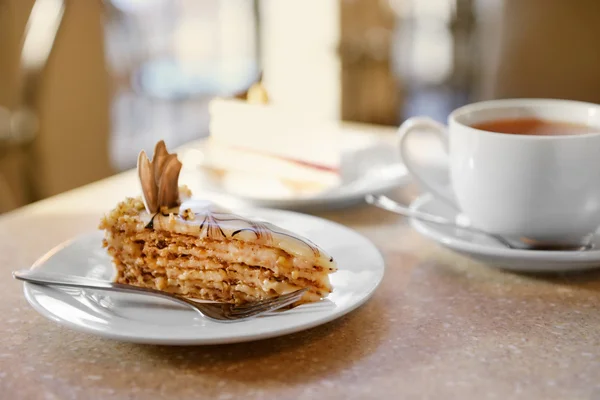 Sweet piece of cake in saucer on table close up — Stock Photo, Image