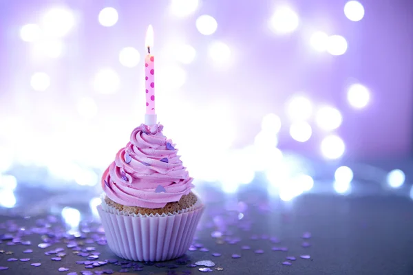 Pembe krema buzlanma ve glitter arka plan üzerinde mum ile cupcake — Stok fotoğraf