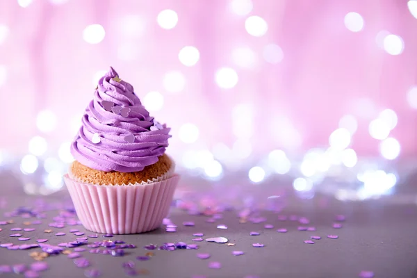 Cupcake dengan icing krim ungu pada latar belakang berkilau — Stok Foto