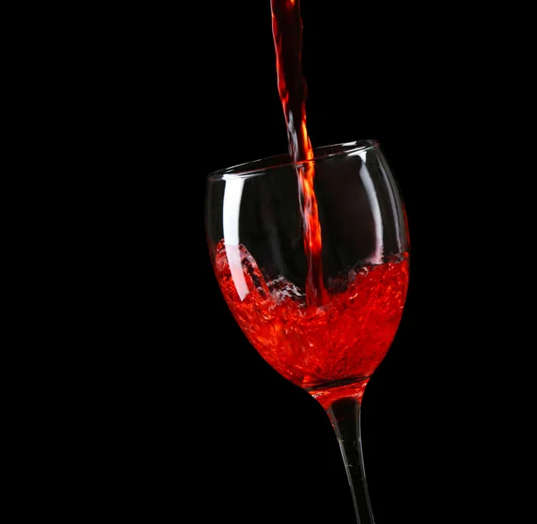 Wine pouring in glass on black background — Stock Photo, Image