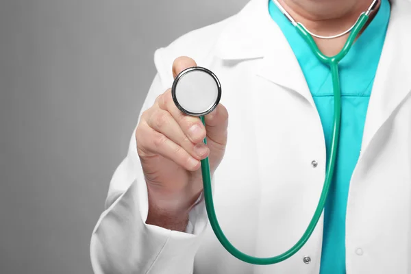 Doctor with stethoscope on grey — Stock Photo, Image