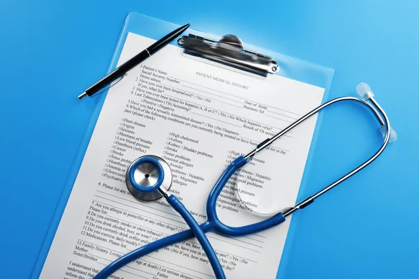 Medical stethoscope, clipboard and pen, on blue background — Stock Photo, Image