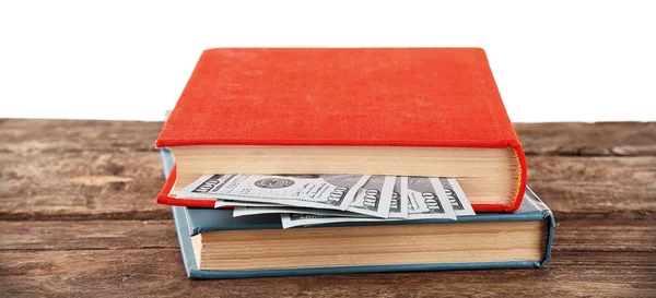 Beyaz zemin üzerine kitaplar ile iç içe geçmiş Doları banknot. Para saklamak — Stok fotoğraf