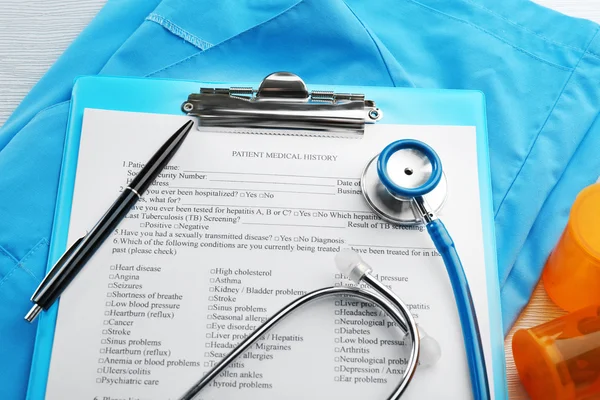 医用听诊器、 剪贴板、 药片和外套，蓝色背景上 — 图库照片