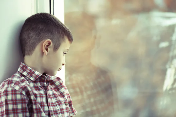 Szomorú fiú ült az ablak közelében — Stock Fotó