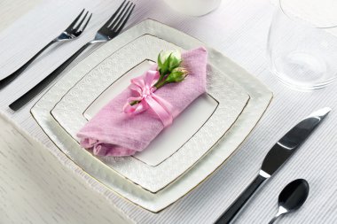 Tablo ayarı yemekleri, çatal bıçak takımı ve beyaz arka plan üzerinde çiçekler