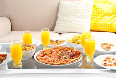 Evde pizza ve içecekler için arkadaşları ile tablo