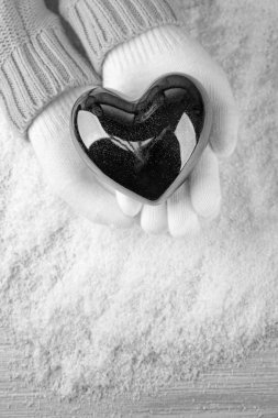 Ellerinde siyah kalp tutan eldiven