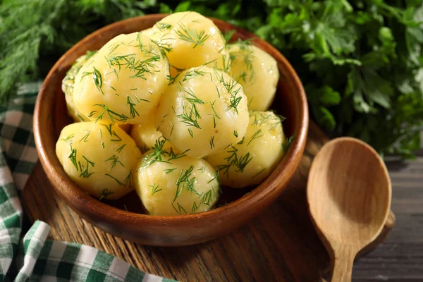 Kokt potatis med greener i skål på bordet på nära håll — Stockfoto