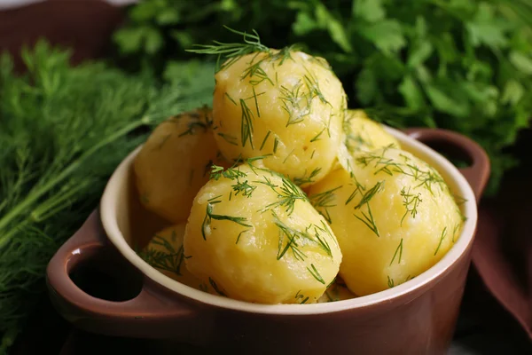 Las patatas cocidas con la verdura en la escudilla a la mesa se acercan —  Fotos de Stock