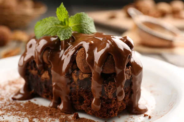 Ein Stück Schokoladenkuchen mit Walnuss und Minze auf dem Tisch, Nahaufnahme — Stockfoto