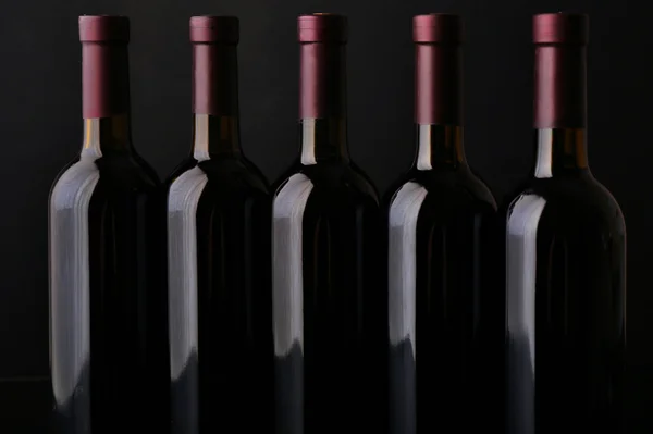 Bor, palack egy sorban, a fekete háttér, közelről — Stock Fotó