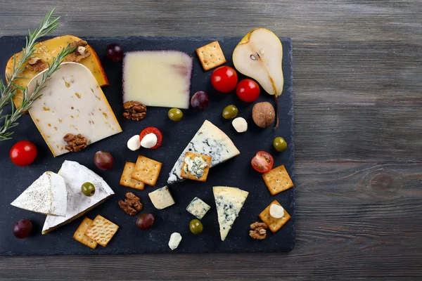 Different kinds of cheese on wooden background — Stock Photo, Image