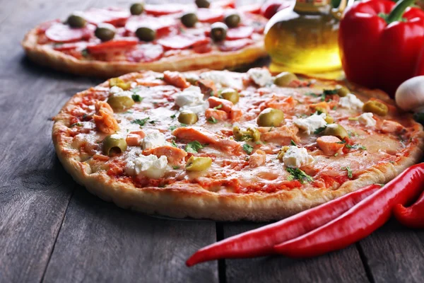 Deliciosas pizzas sabrosas con ingredientes en la mesa, primer plano — Foto de Stock