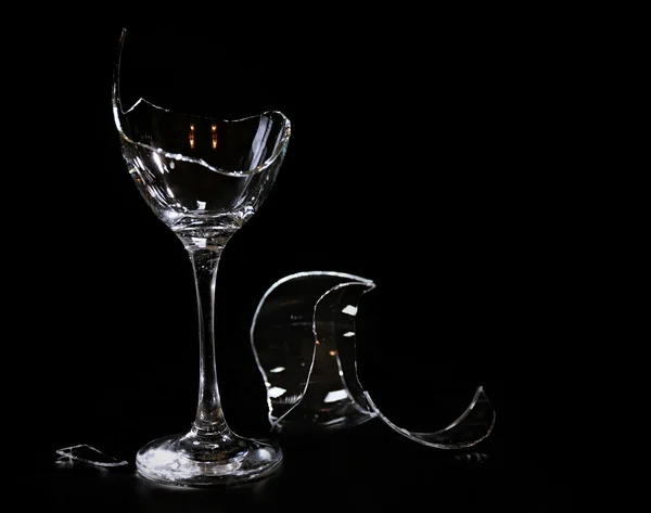 Разбитый бокал вина на черном фоне — стоковое фото