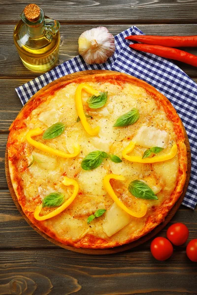 Lezzetli pizza fesleğen ve ahşap zemin üzerine biber ile dekore edilmiş — Stok fotoğraf