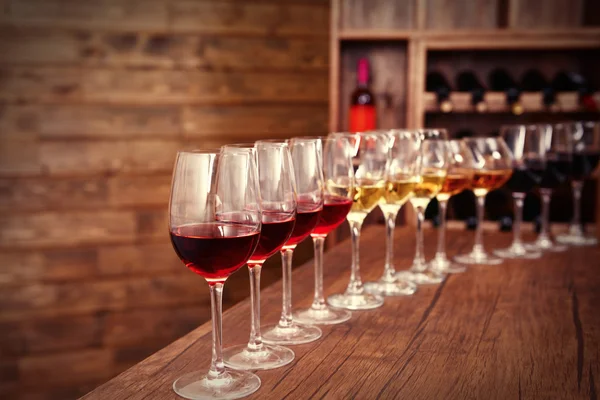 Many glasses of different wine in a row on bar counter — Stock Photo, Image