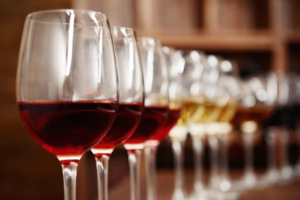 Many glasses of different wine in a row on bar counter — Stock Photo, Image
