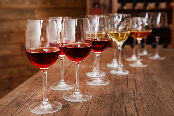 Many glasses of different wine in a row on bar counter — Stock Photo, Image