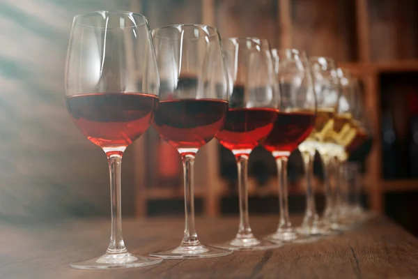 Muchas copas de vino diferentes en una fila en el mostrador de bar — Foto de Stock