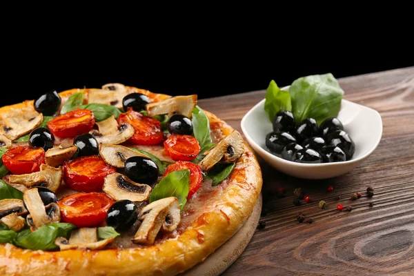 Deliciosa pizza sabrosa con ingredientes en la mesa de madera — Foto de Stock