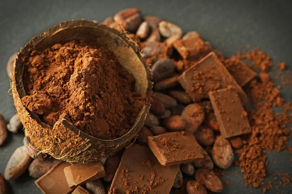 Bowl with aromatic cocoa beans and chocolate on grey background, close up — Stock Photo, Image