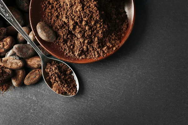 Bowl dengan biji kakao aromatik dan coklat pada latar belakang abu-abu, menutup — Stok Foto
