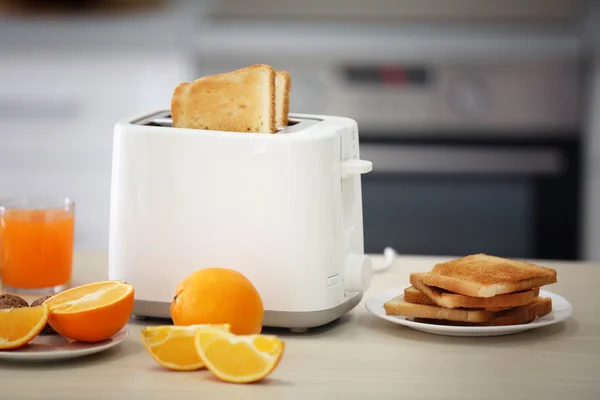 Pemanggang roti dengan hidangan, sandwich dan jeruk di meja dapur ringan — Stok Foto