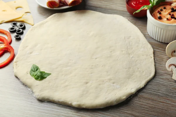 Свежие ингредиенты для приготовления пиццы на деревянном столе — стоковое фото