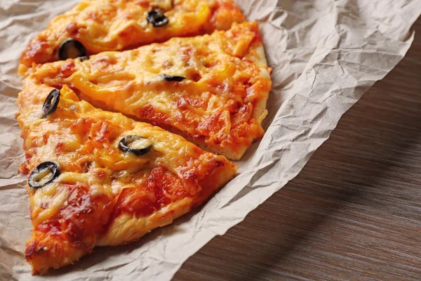 Slices of delicious pizza on a foil, close up — Stock Photo, Image