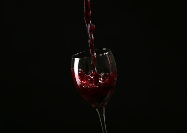 Wein im Glas auf schwarzem Hintergrund — Stockfoto