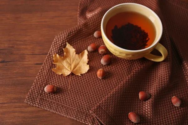 Tasse Tee mit Herbstdekor auf Holztisch. — Stockfoto