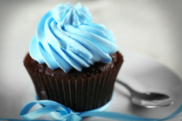 Délicieux cupcake au chocolat avec crème bleue sur table en bois décorée, gros plan — Photo